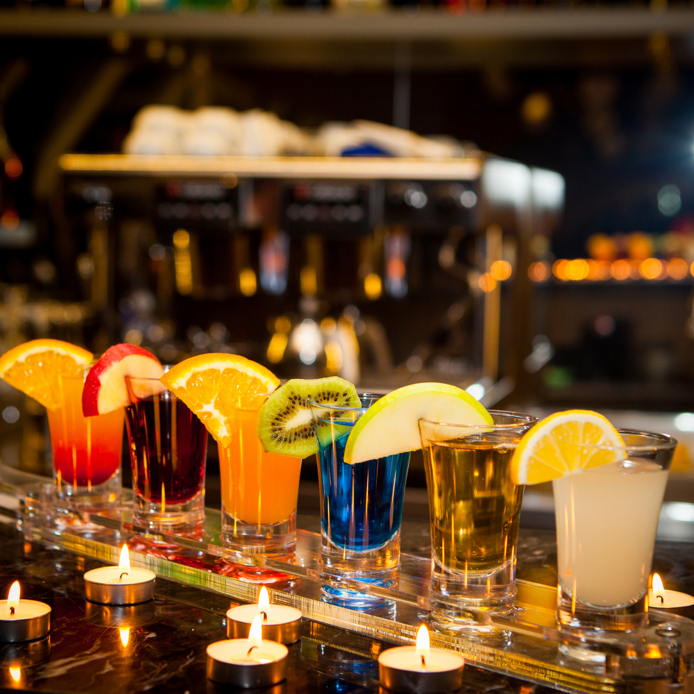 a range of colourful cocktails at a bar